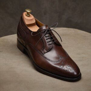 A versatile open-lacing Derby made from premium French box calf leather. Features subtle broguing, a storm welt for durability, and hand-dyed finish.