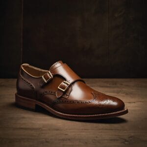A single-strap Monk shoe crafted from luxurious Horween Chromexcel leather with a distinctive brogue motif and a solid brass buckle. A testament to artisanal tradition and bold style.